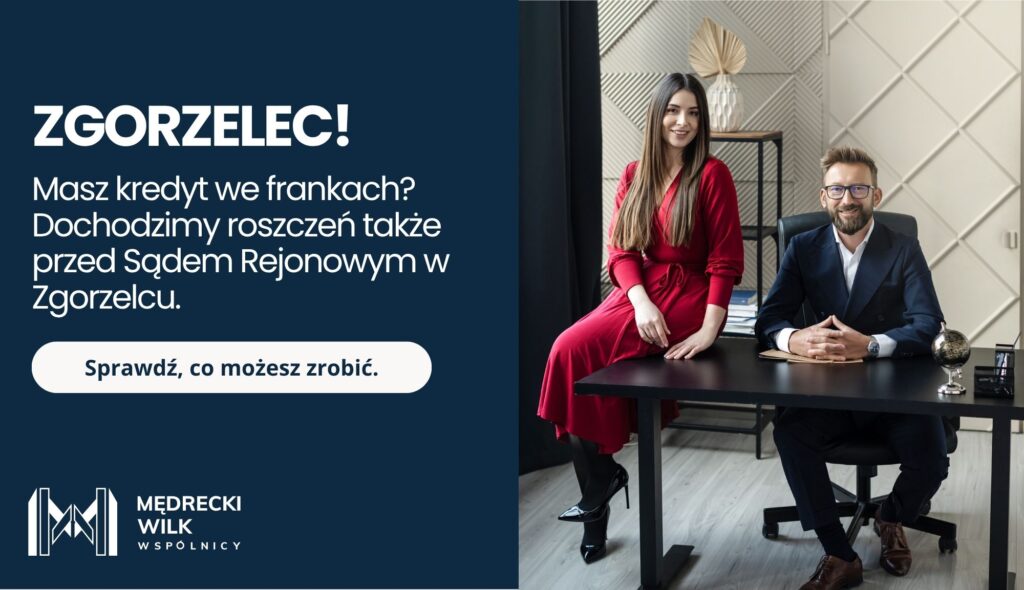 „Kobieta i mężczyzna w eleganckich strojach stojący przy biurku. Po lewej stronie plansza z napisem: Zgorzelec! Masz kredyt we frankach? Dochodzimy roszczeń także przed Sądem Rejonowym w Zgorzelcu. Logo kancelarii Mędrecki Wilk i Wspólnicy oraz przycisk: Sprawdź, co możesz zrobić.”