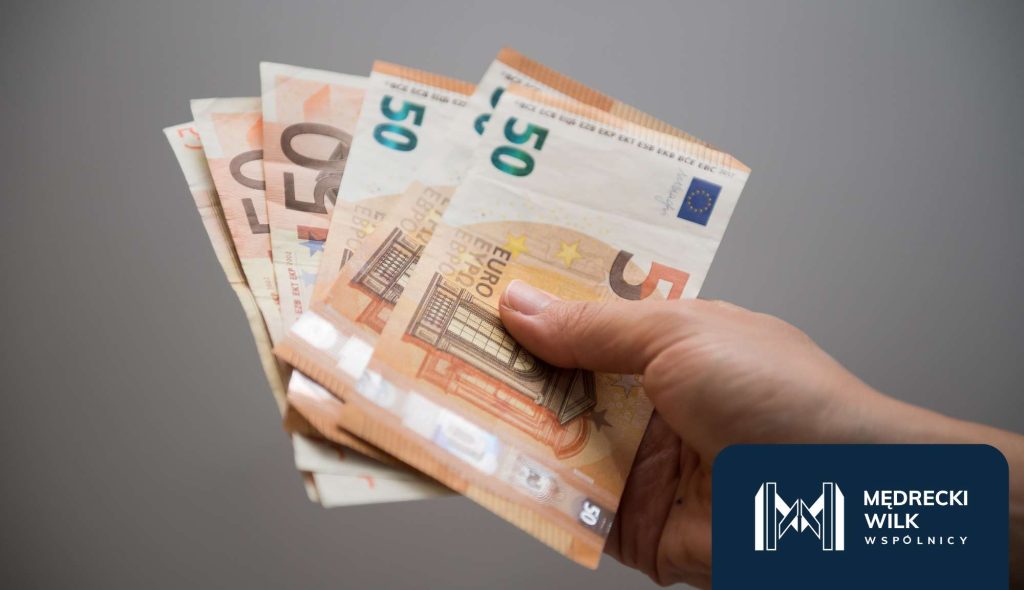 Dłoń trzymająca banknoty w walucie euro