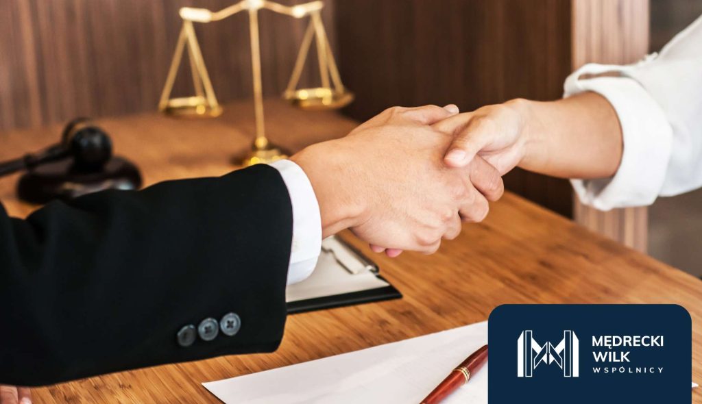 Uścisk dłoni w kancelarii, w tle złota waga