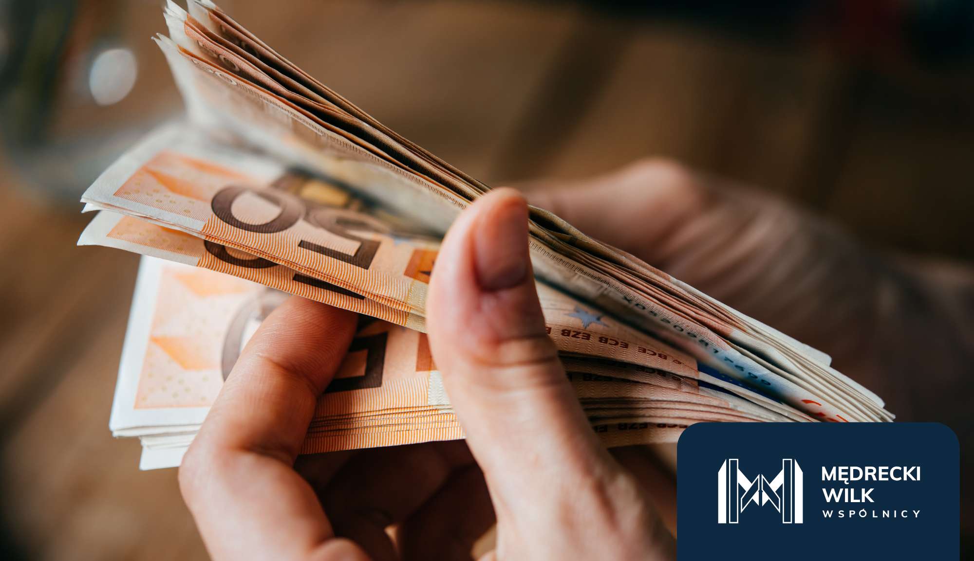 Dłonie przeliczające pieniądze - banknoty w walucie euro