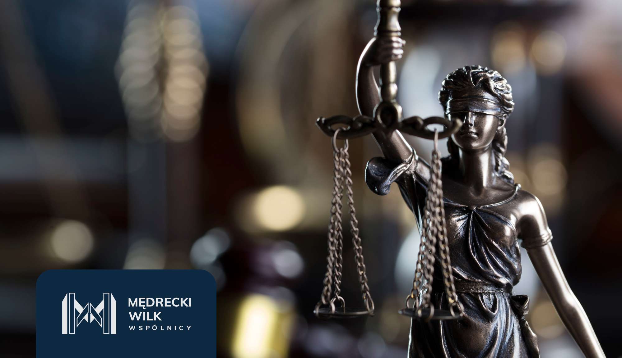 Bronze statue of Lady Justice holding scales, with a dark blue logo panel in the foreground and a blurred courtroom-like background.