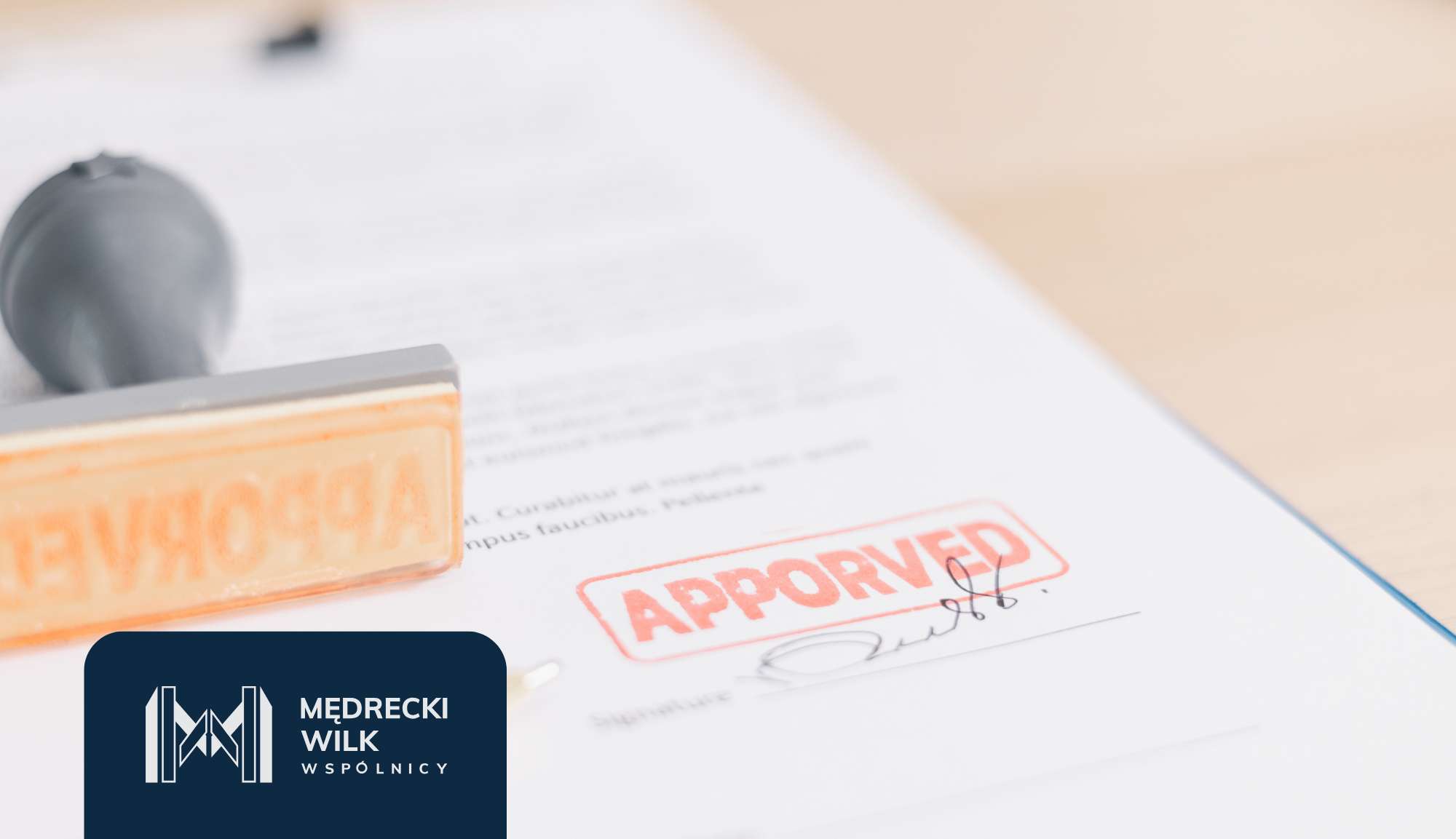 Close-up of a document stamped 'APPROVED' in red, with a dark blue logo area in the bottom-left corner.