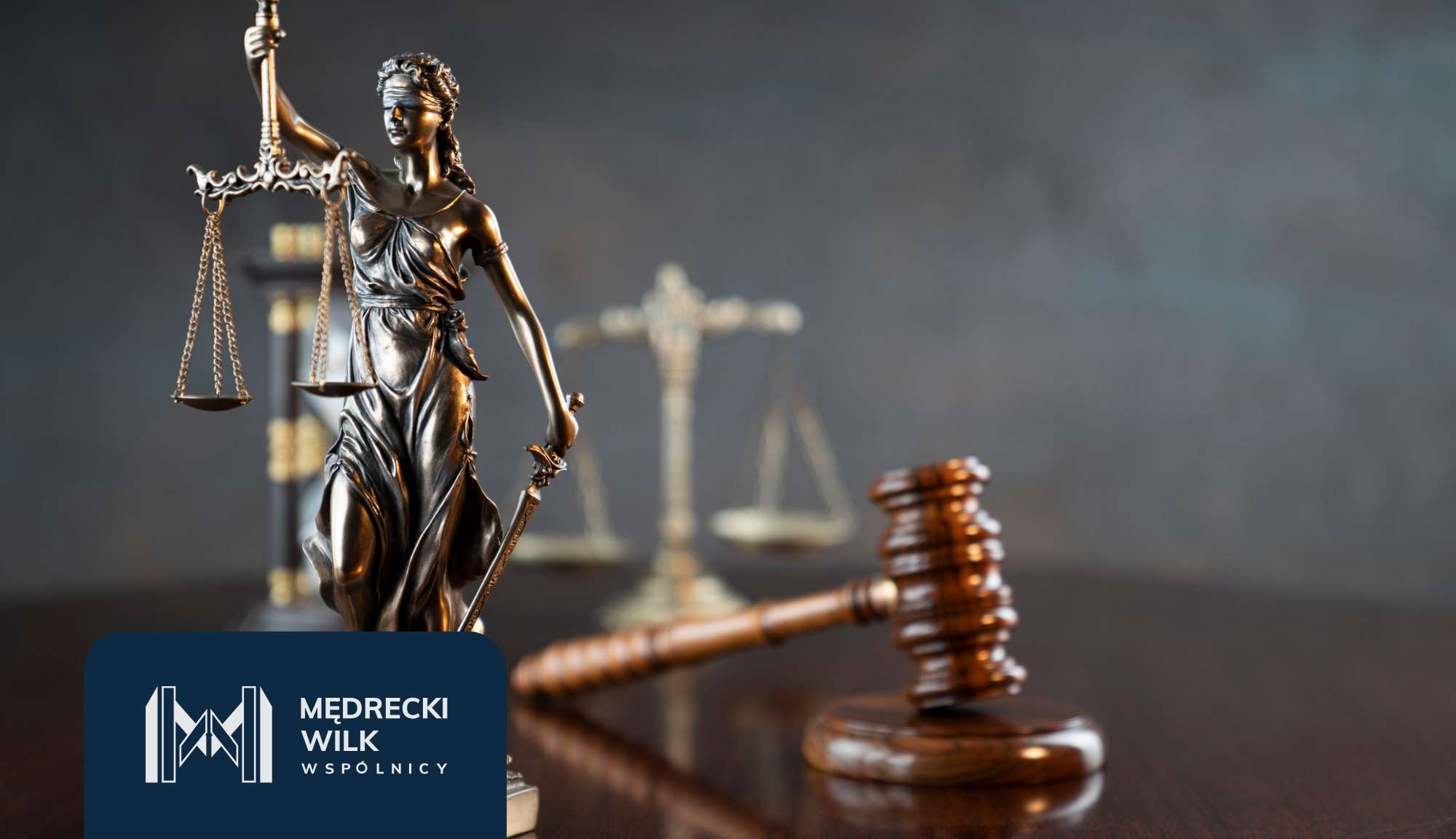 Statue of Lady Justice holding scales with a sword, a gavel on a wooden surface, blurred courtroom backdrop, and a dark blue law firm logo in the bottom-left.
