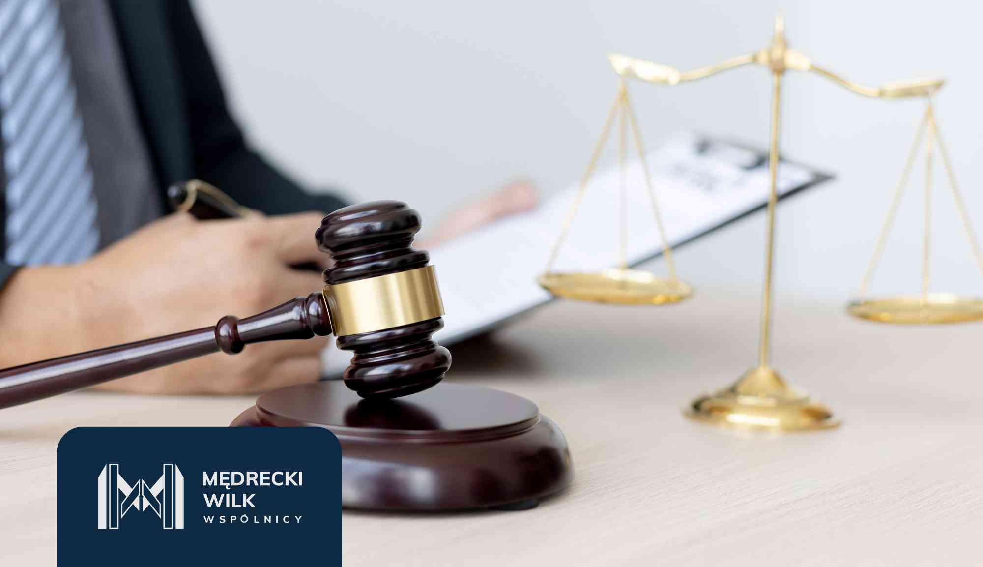 Gavel on a desk with scales of justice in the background and a legal firm logo in the corner.