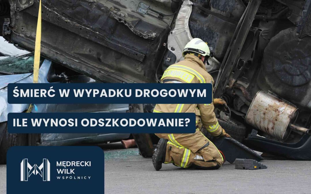 Strażak w piaskowym kombinezonie i kasku klęczy przy poważnie rozbitym, wywróconym na bok ciemnym samochodzie. Podwozie auta jest uniesione, a obok widoczny jest fragment innego zgniecionego pojazdu. Na grafikę nałożone dwa granatowe paski z białymi napisami: „ŚMIERĆ W WYPADKU DROGOWYM” oraz „ILE WYNOSI ODSZKODOWANIE?”. W lewym dolnym rogu logotyp kancelarii Mędrecki Wilk i Wspólnicy.