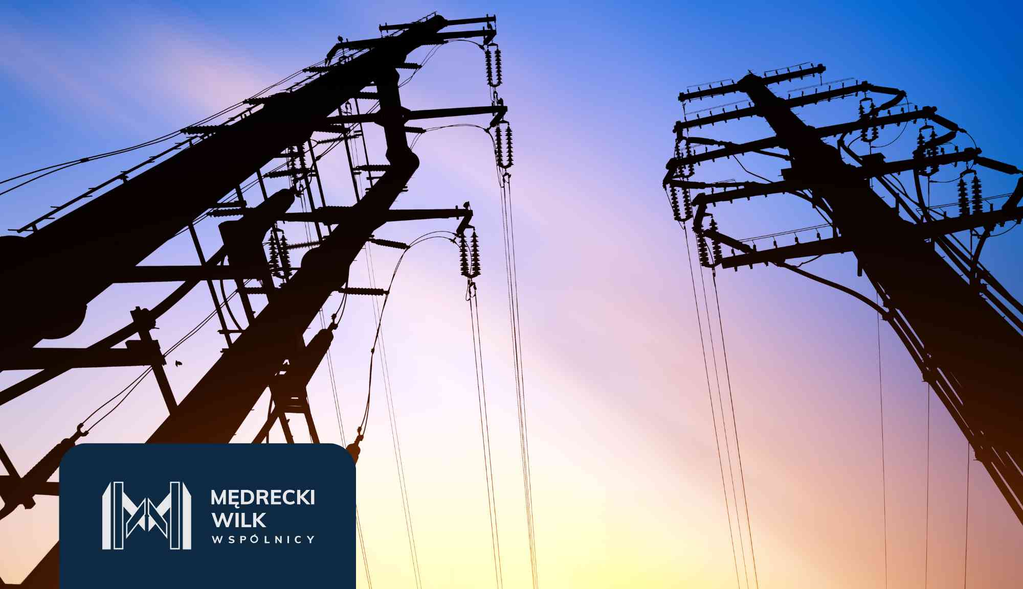 Power lines and tall transmission towers silhouetted against a colorful sunset sky, with a dark blue overlay and company logo in the lower-left corner reading 'Medrecki Wilk Wspólnicy'