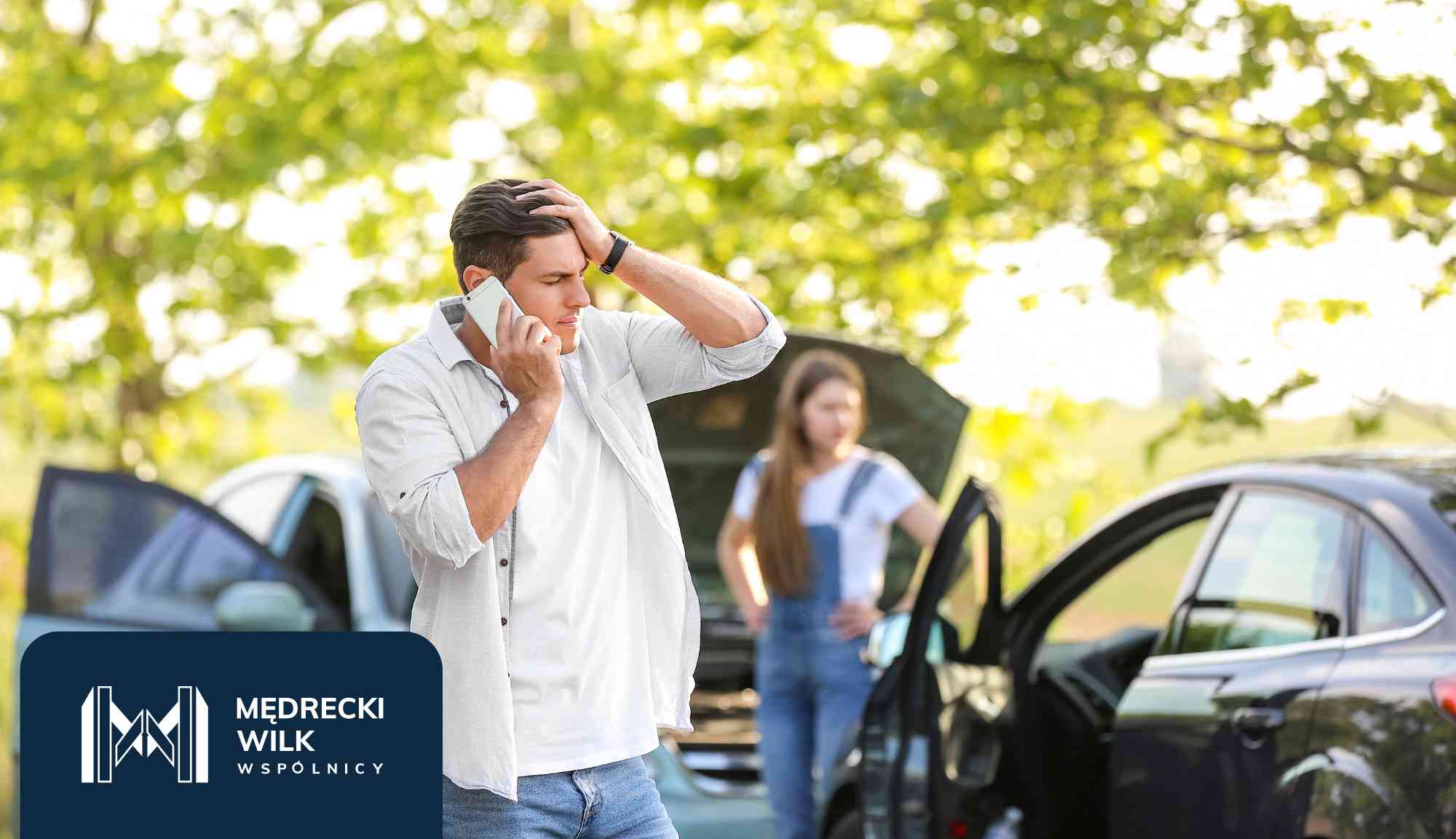 Man on a cellphone with a stressed expression, hand on his head, beside an open car door; a woman stands in the background near another car; dark blue logo panel in the bottom-left corner.